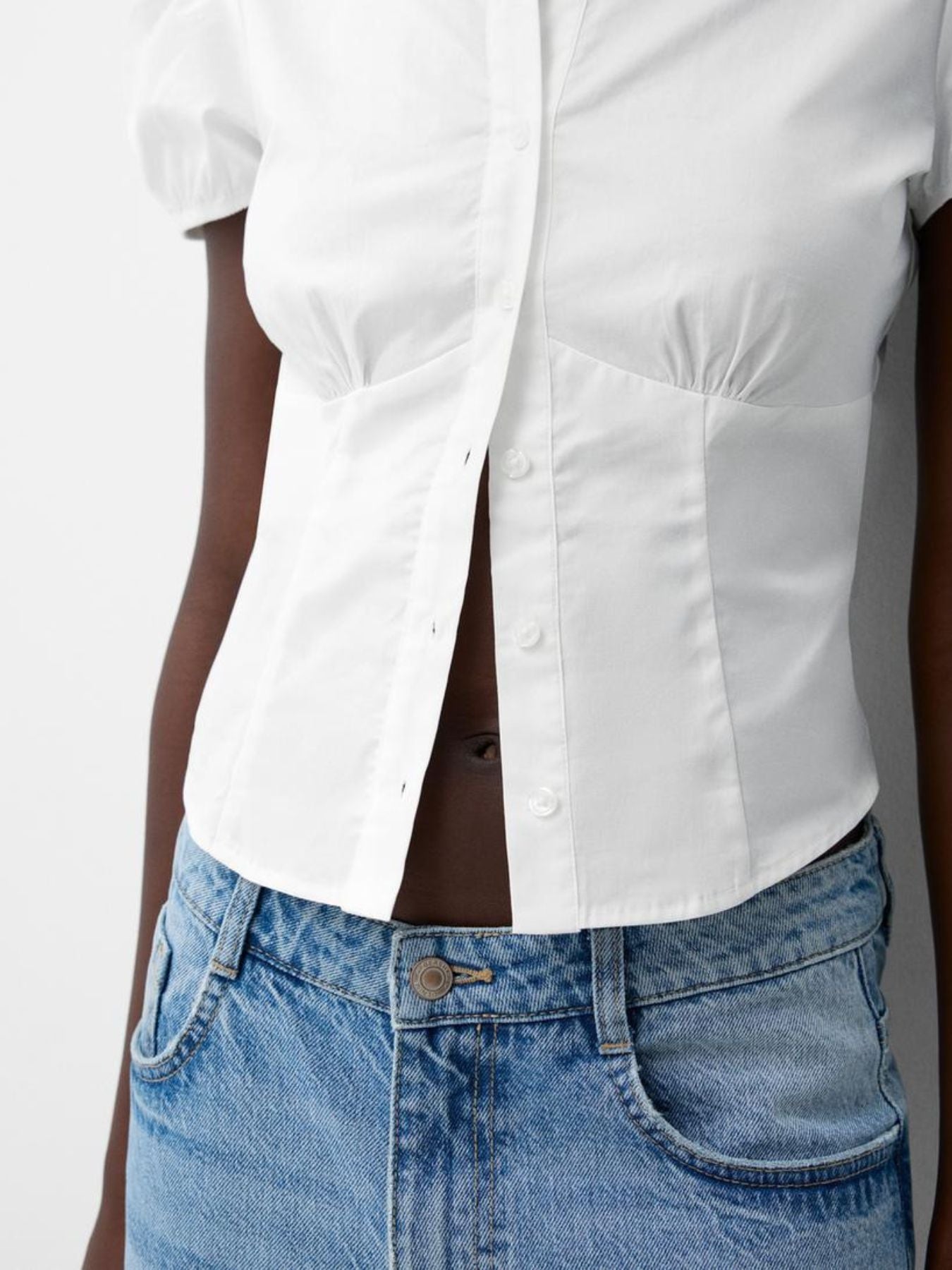 White puff sleeve fitted button-up shirt with ruched detailing and cropped length.