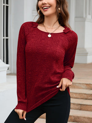 Wine textured knit top with raglan sleeves and a scoop neckline with ruffled detail.