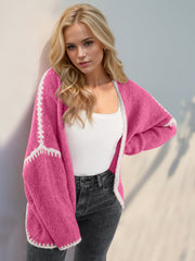 Pink oversized knit cardigan with contrast white stitching detail on sleeves and hem