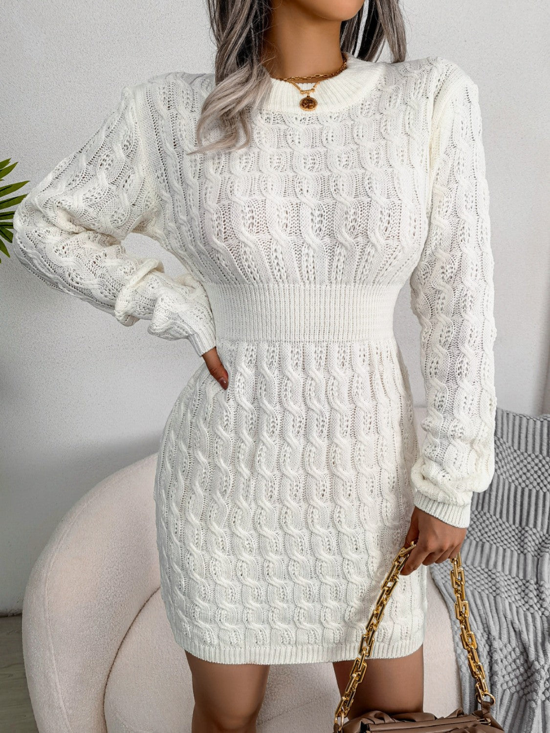 White cable knit mini dress with long sleeves and a sculpted fit.