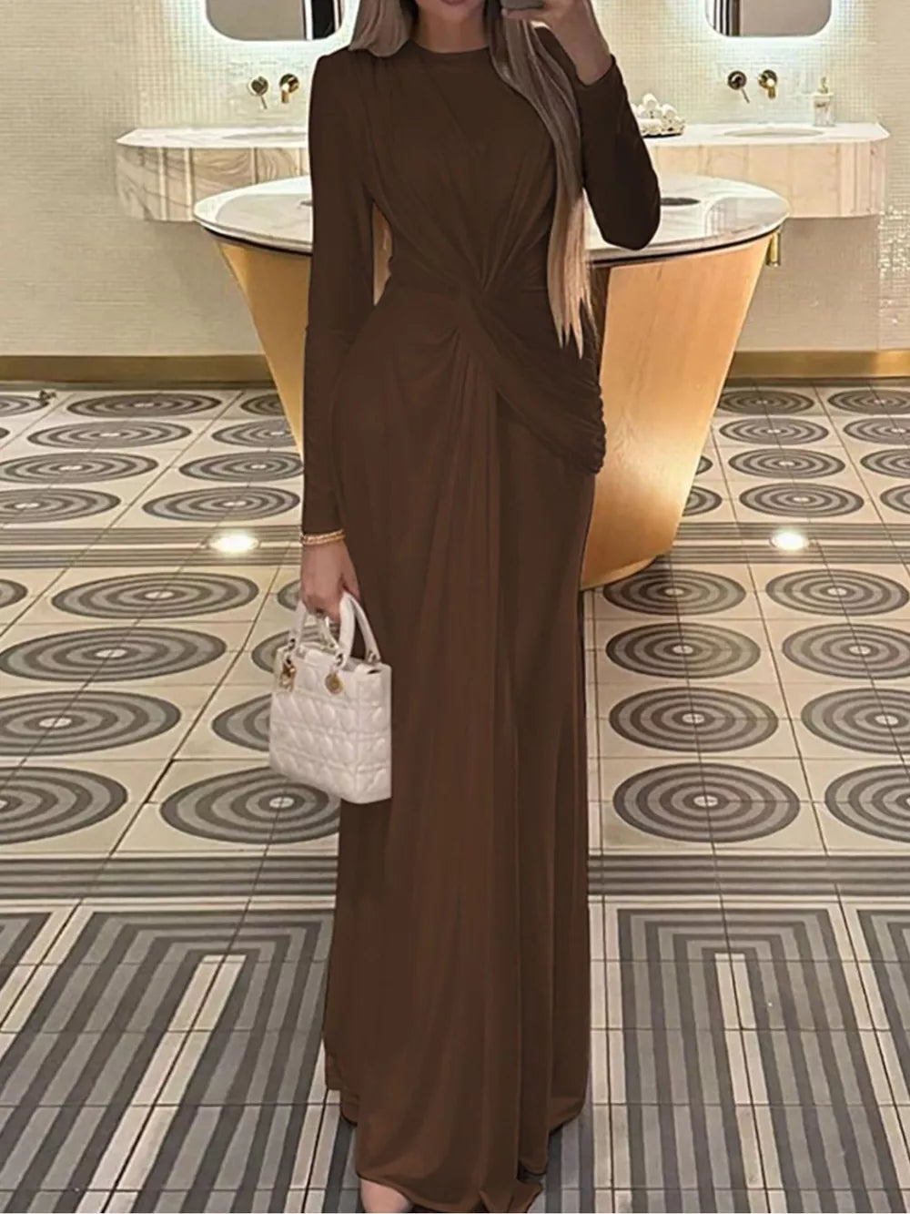 Brown ruched long sleeve maxi dress with a twist detail and boat neckline.