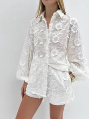White embroidered two-piece shirt and shorts set with floral details and balloon sleeves.
