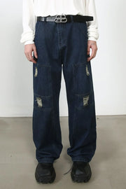 Dark wash denim wide-leg jeans with distressed panel pockets and a relaxed fit.
