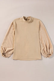 Tan textured blouson top with Swiss dot puff sleeves and mock neck.
