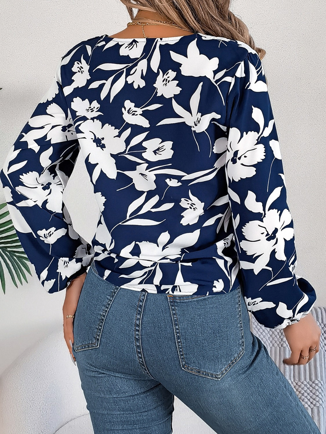 Navy floral knot-front blouse with ruffled cuffs and long sleeves.