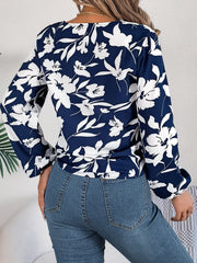 Navy floral knot-front blouse with ruffled cuffs and long sleeves.