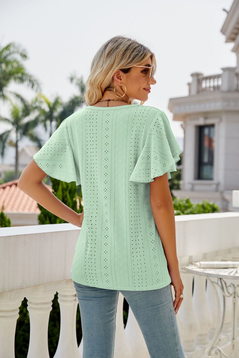 Light green eyelet flounce sleeve crew neck top with allover perforations.