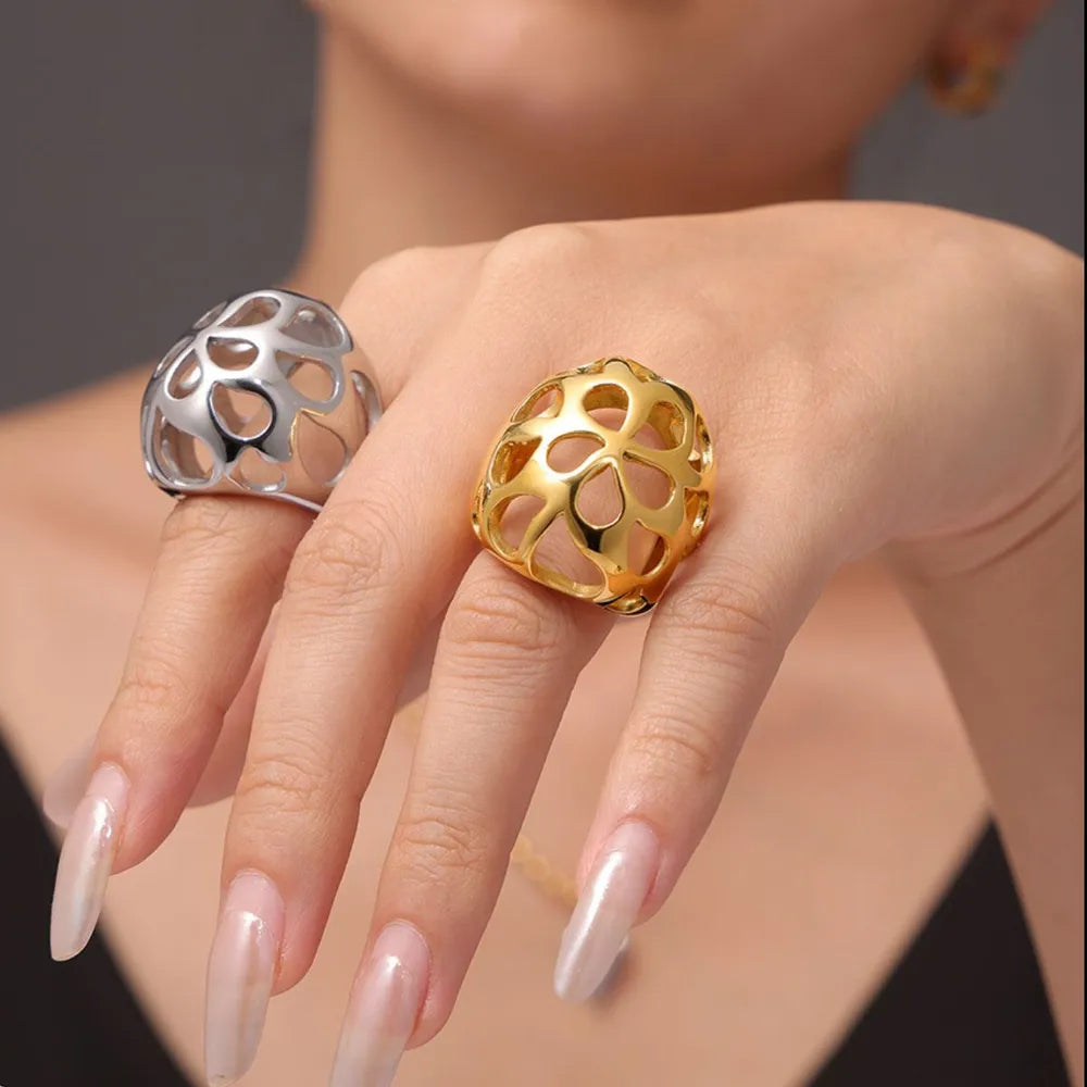 Openwork orb rings in gold and silver with cut-out details.