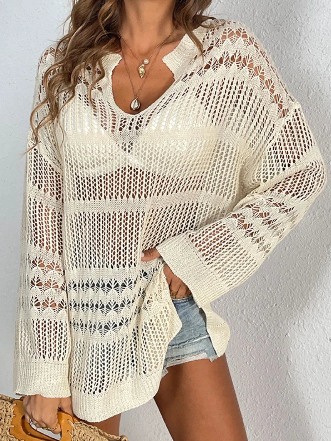 Beige open-knit beach cover-up with V-neck, long sleeves, and slit hem.