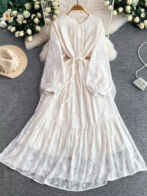 Elegant white embroidered tie-waist midi dress with tiered hem and balloon sleeves.
