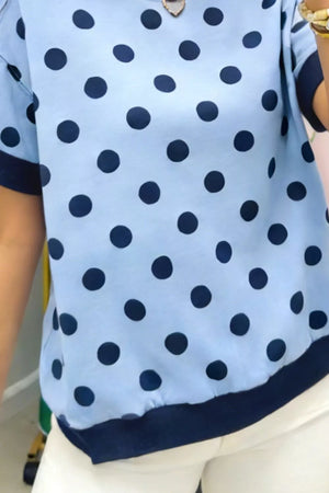 Light blue polka dot knit sweater with navy trim and short sleeves.