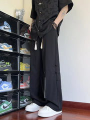 Black wide-leg sweatpants with tassel accents and knot button details.