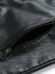 Black plus-size moto jacket detail showing a zippered pocket with silver hardware.