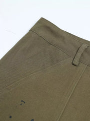 Olive green cotton cargo pants with black paint splatter detail and button fly.