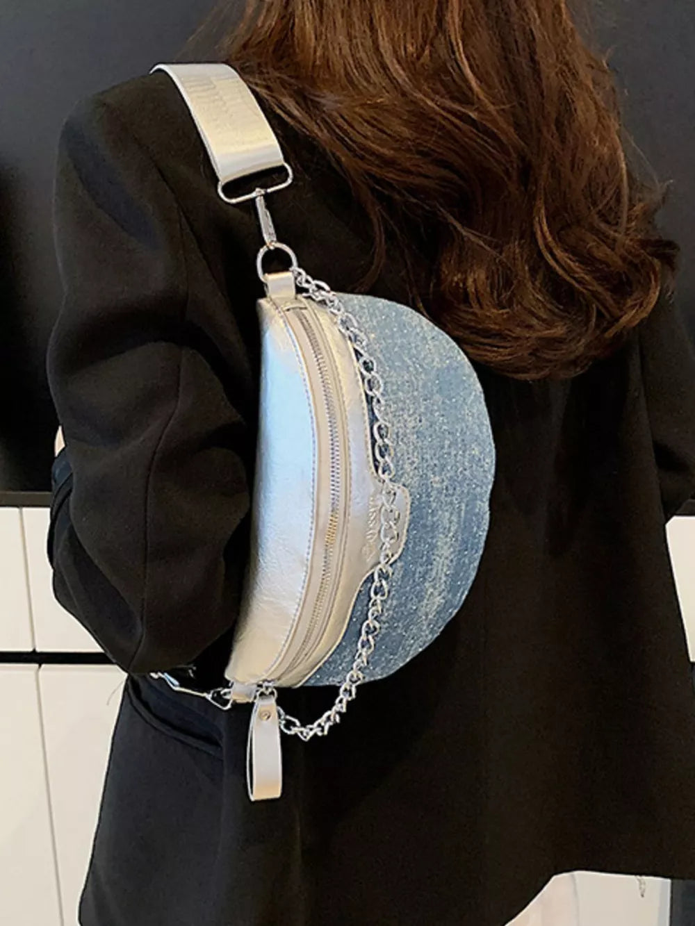 Crescent mini denim crossbody bag with silver metallic accents and chain detail.
