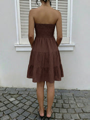 Dark brown strapless mini dress with gathered bodice and tiered ruffles.