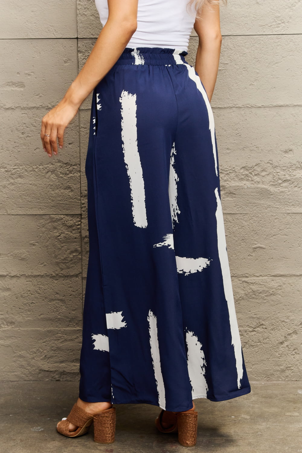 Navy palazzo trousers with white brushstroke print and elastic waist.