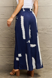 Navy palazzo trousers with white brushstroke print and elastic waist.
