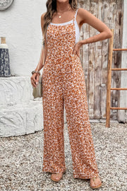 Abstract floral wide-leg romper with pockets and spaghetti straps, worn over a white tank top.