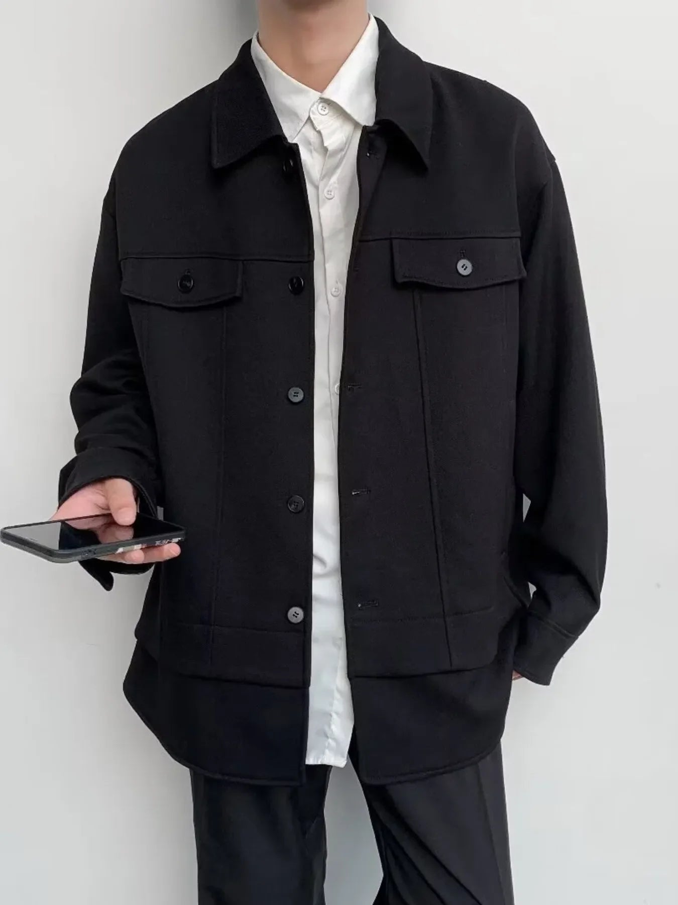 Black oversized button-down jacket with dual chest pockets and button closure.