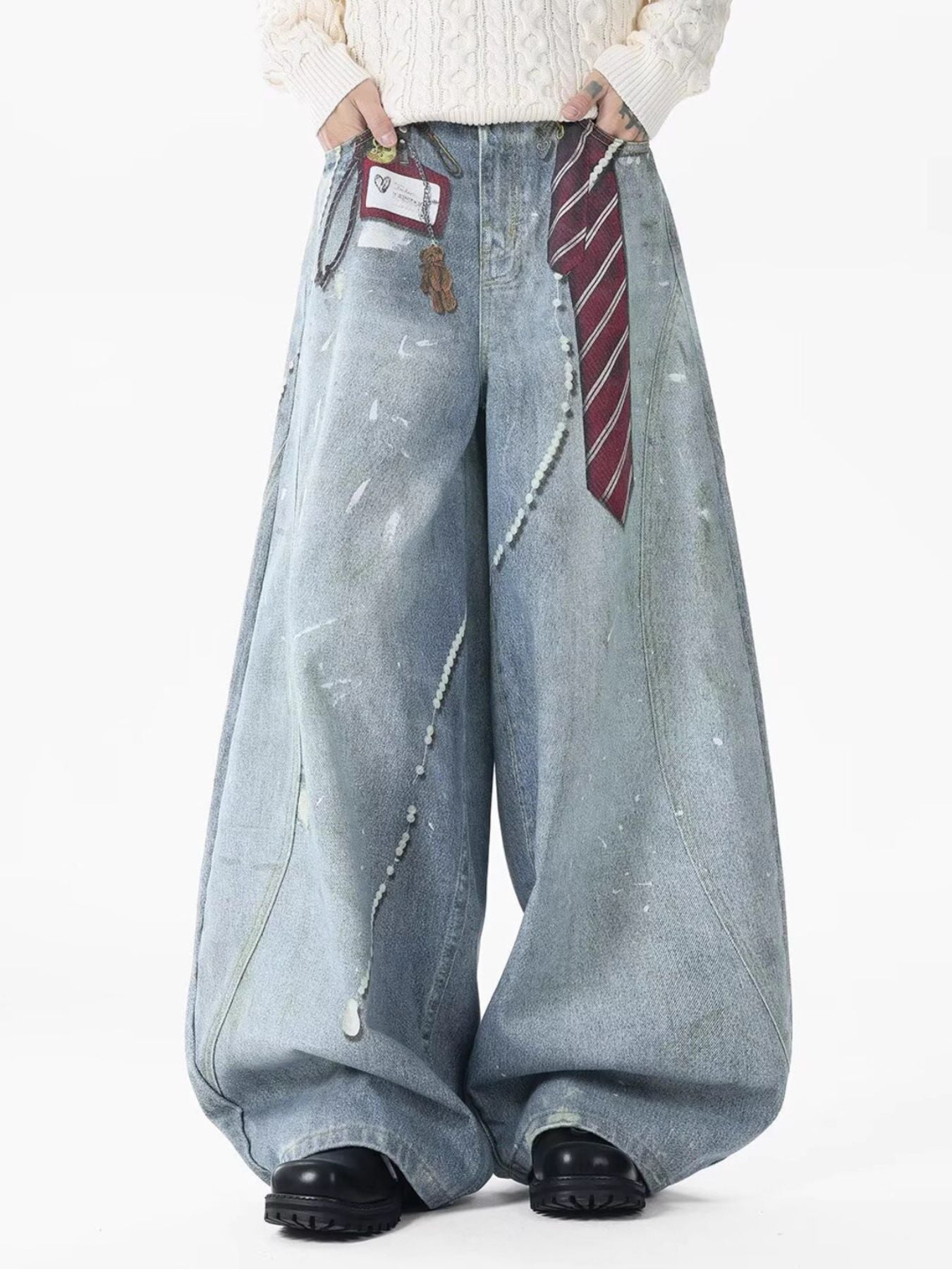 Oversized light wash denim jeans with pearl accents and paint splatters.