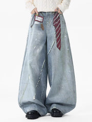 Oversized light wash denim jeans with pearl accents and paint splatters.