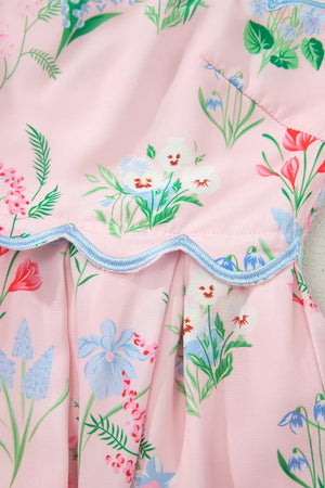 Pink midi dress with a multicolor wildflower print and blue scalloped trim detail.
