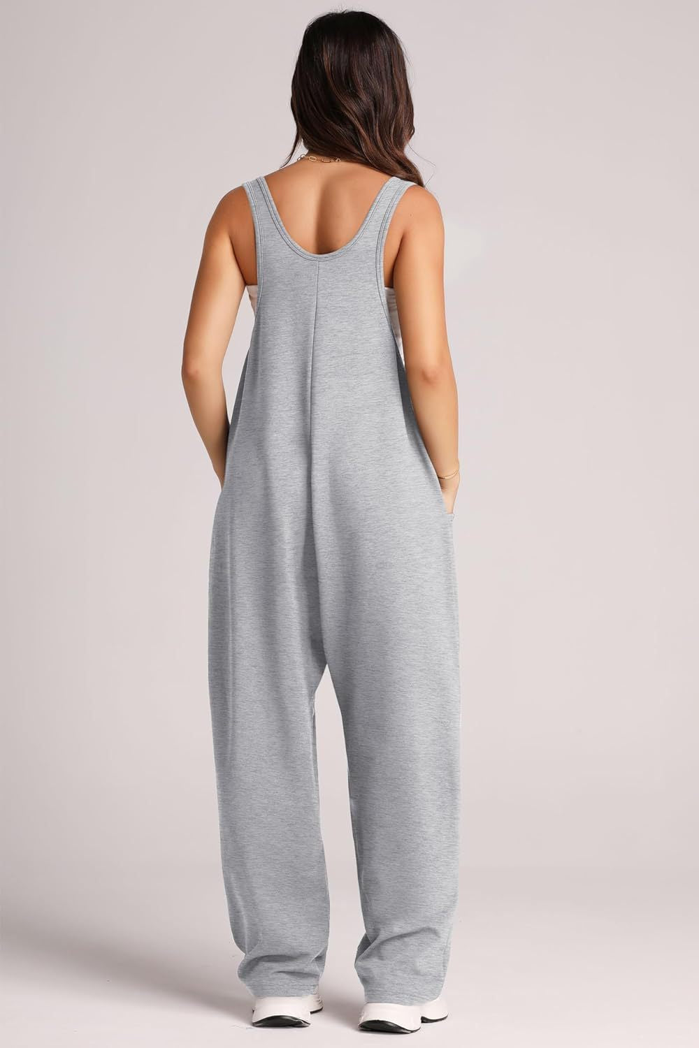 Relaxed fit pocketed tank jumpsuit in light gray with wide legs and side pockets.