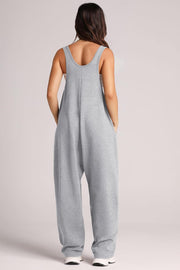 Relaxed fit pocketed tank jumpsuit in light gray with wide legs and side pockets.