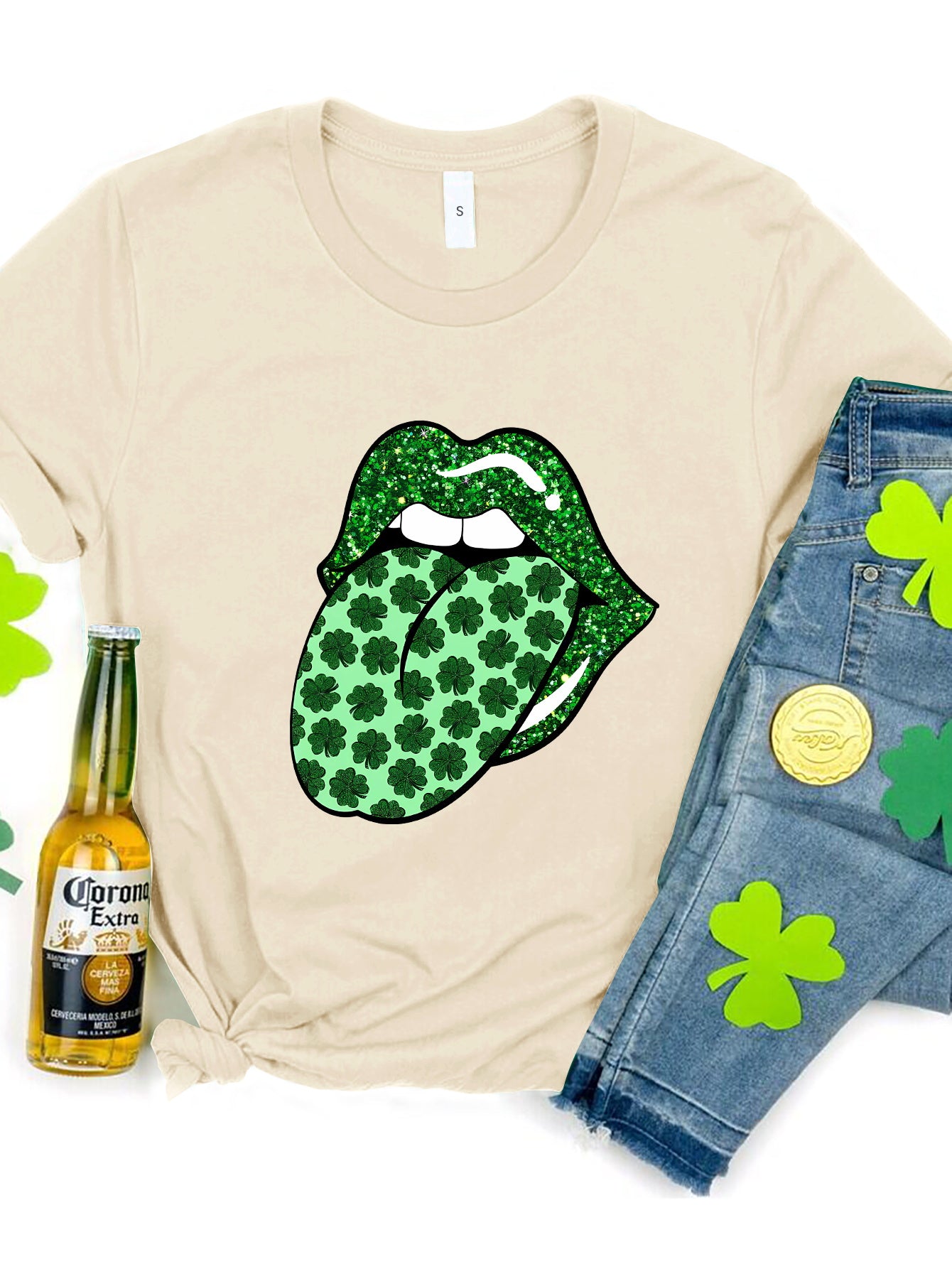 Light yellow graphic tee with glittery green lips and a shamrock-covered tongue.