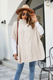 Cream cable knit turtleneck poncho with side slit, acrylic.