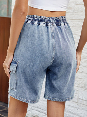 Denim cargo shorts in dusty blue with elastic drawstring waist and side cargo pocket.