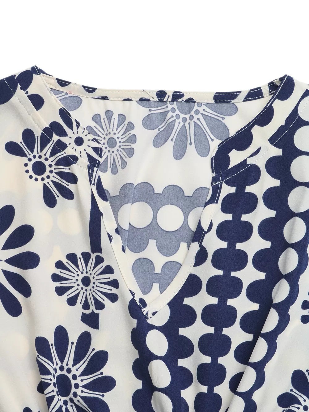 Maxi dress with navy floral and polka dot print, V-neck, and cutout waist detail.