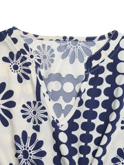 Maxi dress with navy floral and polka dot print, V-neck, and cutout waist detail.