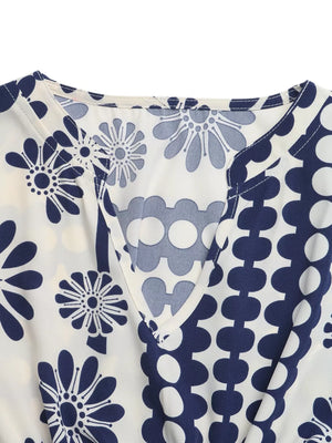 Maxi dress with navy floral and polka dot print, V-neck, and cutout waist detail.