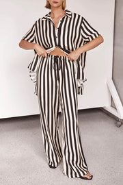 Vertical stripe lounge set in white and black with buttoned shirt and drawstring pants.