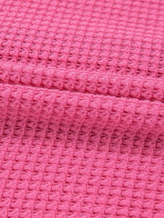 Waffle-knit maternity shirt in cerise pink with button detail.