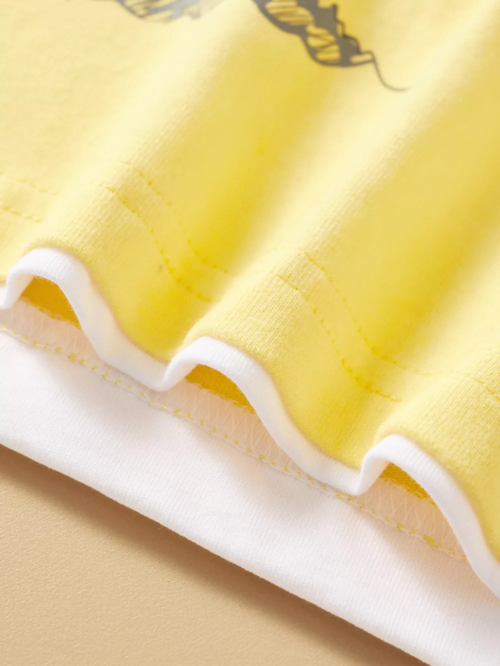 Yellow cotton t-shirt with white trim and alligator graphic detail.