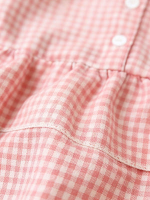 Blush pink gingham baby dress with ruffles and buttons.