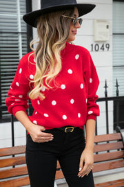 Red polka dot knit sweater with balloon sleeves and a crew neck.