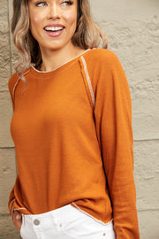 Caramel waffle knit raglan sweater with contrast stitching and crew neck.