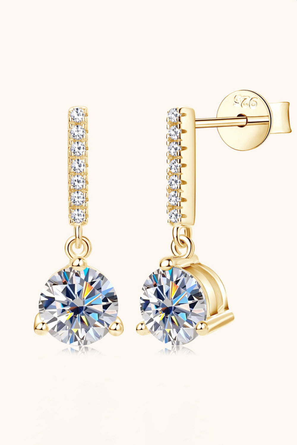 Gold drop earrings with clear cubic zirconia studs and a large faceted gem.