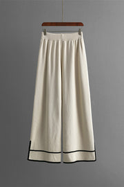 Cream acrylic lounge pants with elastic waist and black trim detail at hem