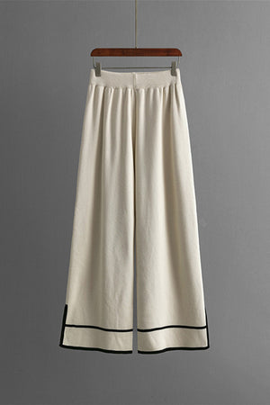 Cream acrylic lounge pants with elastic waist and black trim detail at hem
