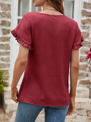Burgundy t-shirt with textured fabric and ruffled short sleeves.