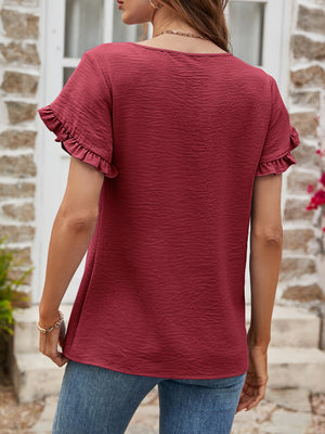 Burgundy t-shirt with textured fabric and ruffled short sleeves.
