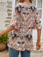 Paisley print blouse with ruffle hem and flutter sleeves in tangerine and burgundy colors.