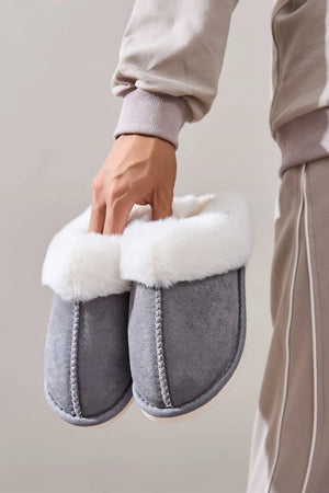 Dark gray suede house slides with white shearling trim and contrast stitching.