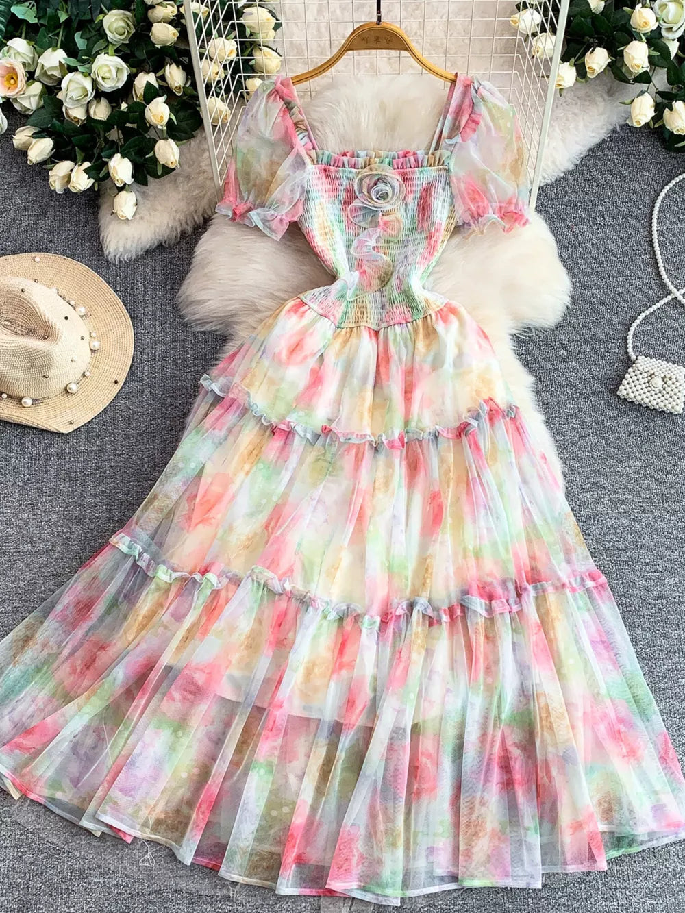 Floral tiered midi dress with smocked bodice and puff sleeves in a pastel watercolor print.