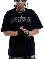 Black cotton oversized t-shirt with a textured logo graphic on the chest.